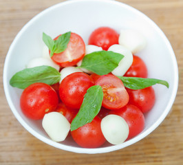 cherry tomatoes, basil and mozzarella cheese on a plate