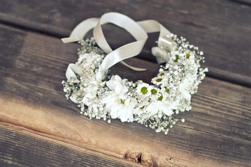 Bracelet with chamomile flowers on the wooden floor