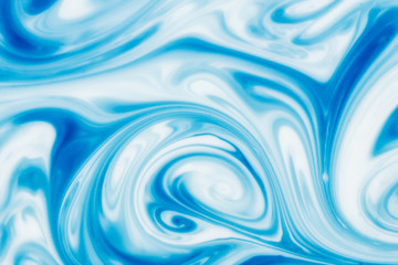 Blue ink flowing in milk texture.