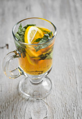 green tea with mint and lemon in a glass mug 