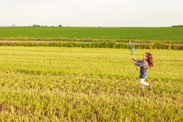 Naklejka na ściany i meble little girl walking in the field 