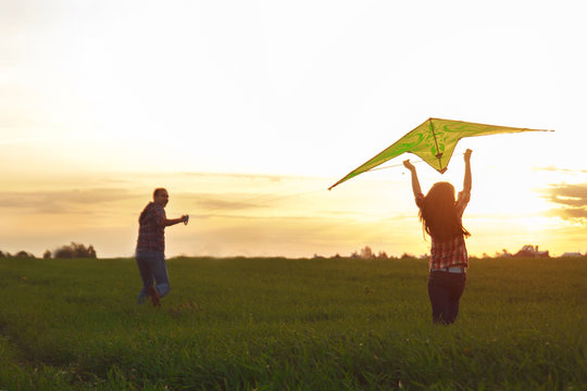 A man with a girl launches a kite

