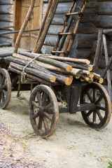 Fototapeta na wymiar Old wooden cart with attached logs on it