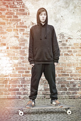  teenage boy with hoodie standing on a long board