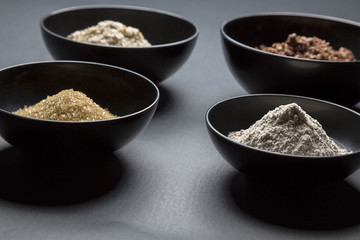 some black bowls with baking ingredients