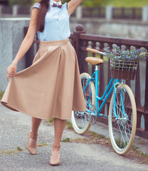 Young beautiful, elegantly dressed woman with bicycle. Beauty, f