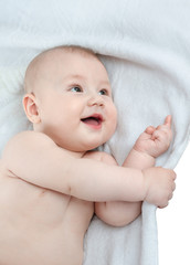 baby lying on the blanket and pointing her finger up