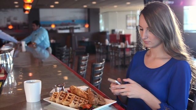 An attractive woman taking cell phone photo of her lunch
