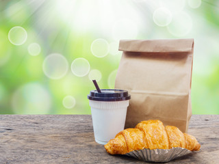 coffee and croissant with paper bag for breakfast