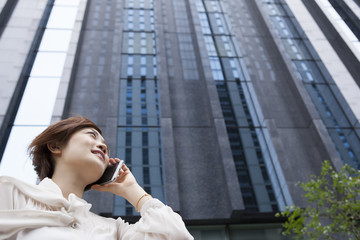 Woman on the phone in front of a high-rise building