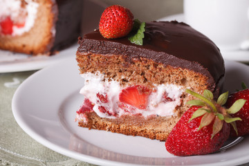 Sponge cake with strawberries and chocolate on a table macro