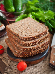Fototapeta na wymiar Wholegrain rye bread with bran and seeds on wooden table, healthy eating