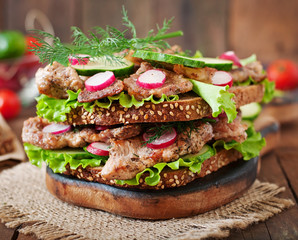 Sandwich with meat, vegetables and slices of rye bread