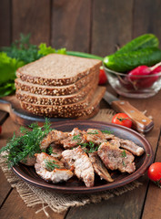 Fried pieces meat and rye bread for sandwiches