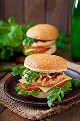 Sandwich with chicken burger, tomatoes, cheese and lettuce