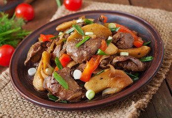 Roast chicken liver with vegetables on wooden background