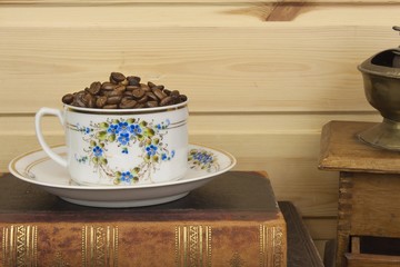 Mug coffee beans and old books are on the shelf. 
