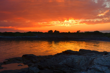 Obraz premium Sunset on a rocky shore.