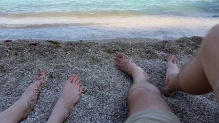 Jambes sur la plage de cailloux