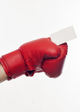 Hand in boxing gloves holding business card