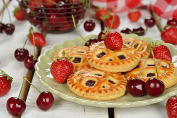 Mini pies with strawberry and cherry on a white background