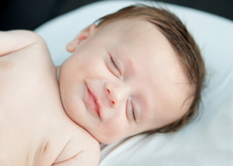 Tender baby smiling while nap.