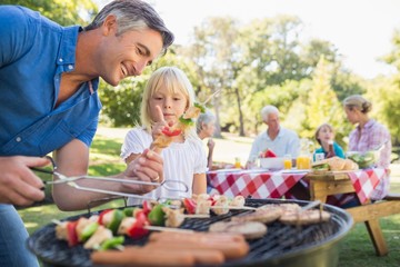 Happy father doing barbecue with her daughter