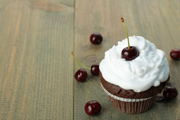 Chocolate Cupcakes with cherries on wooden background