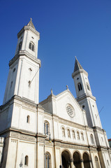 Fototapeta premium Kirche/Katholische Pfarr- und Universitätskirche St. Ludwig in München, Sakralbau im Rundbogenstil, Kirche mit zwei Türmen, Baudenkmal, blauer wolkenloser Himmel