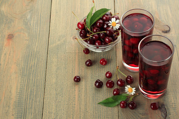 Closeup of fresh juice with sweet cherries on a wooden background