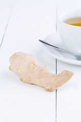 Fresh ginger and cup of green tea.