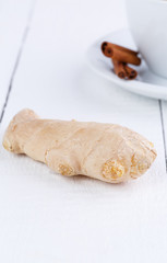 Fresh ginger with cinnamon on wooden table.