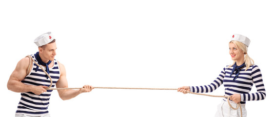 Male and a female sailor playing tug-of-war