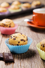muffins with chocolate in colorful tins served with a cup of cof