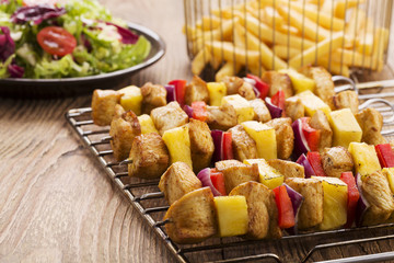 Grilled chicken skewers with pineapple, peppers and onions serve