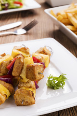 Grilled chicken skewers with pineapple, peppers and onions serve