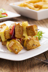 Grilled chicken skewers with pineapple, peppers and onions serve