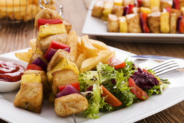 Grilled chicken skewers with pineapple, peppers and onions serve