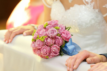 Newlyweds with wedding rose bouquet at the church