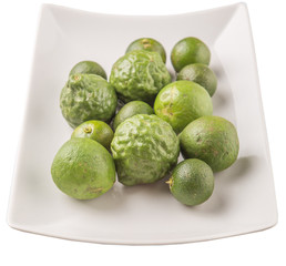 Lime, makrut or kaffir lime and calamansi on white plate