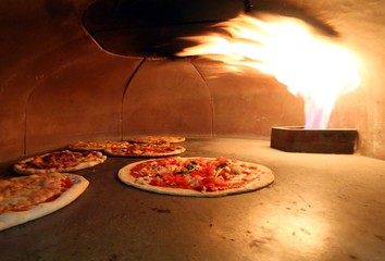 many pizza in the very hot stove
