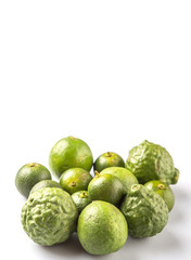 Lime, makrut or kaffir lime and calamansi over white background