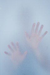 Hands touching frosted glass