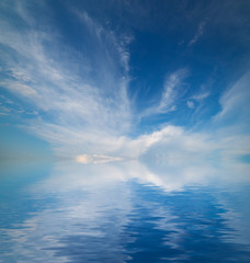 Sky with clouds reflected in water surface.