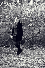 Walking young blonde woman. Black-white photo.