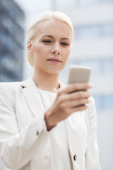 serious businesswoman with smartphone outdoors