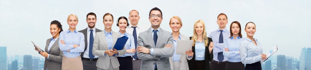 group of happy businesspeople over city background
