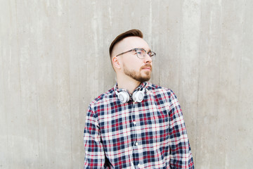 happy young hipster man with headphones over wall