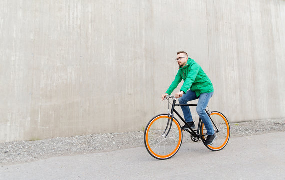 happy young hipster man riding fixed gear bike