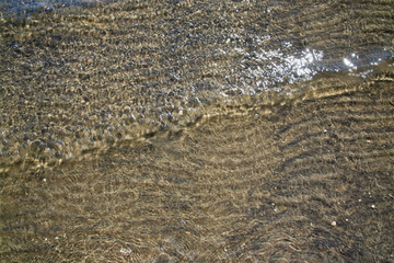 Fototapeta na wymiar Abstract water pattern with small wave and glitter, seaside natural organic landscape detail.